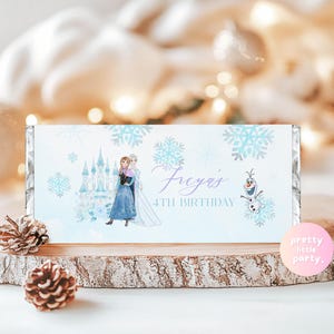 May include: A light blue candy bar wrapper with a Frozen theme, featuring illustrations of Elsa and Anna, snowflakes, and a castle. The text says "Freya's 4th Birthday" and includes Olaf.