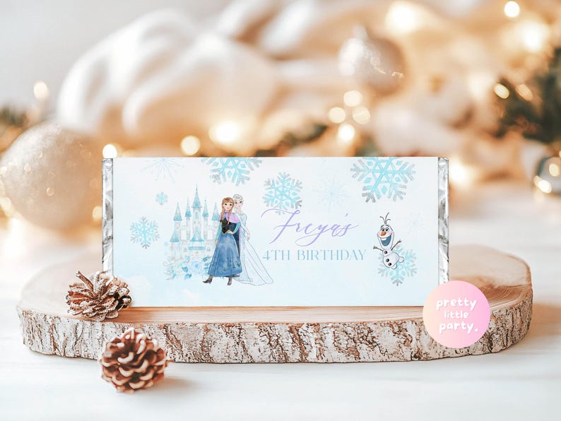 May include: A light blue candy bar wrapper with a Frozen theme, featuring illustrations of Elsa and Anna, snowflakes, and a castle. The text says "Freya's 4th Birthday" and includes Olaf.