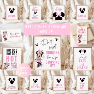 May include: A set of framed party signs with a Minnie Mouse theme. The signs feature pink and black accents, with phrases like "Drinks," "Snacks," and "Don't forget goodies." The signs are designed for a party.