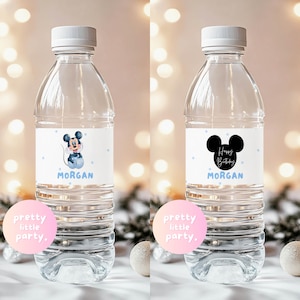 Puede incluir: Dos botellas de agua de pl&aacute;stico transparente con tapas blancas. Una botella tiene una etiqueta con un dibujo de Mickey Mouse, el nombre "Morgan" y lunares azules. La otra botella tiene una etiqueta con orejas de Mickey, las palabras "Happy Birthday" y el nombre "Morgan".