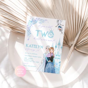 Pode incluir: Um convite de aniversário com tema Frozen com um fundo de aquarela. O convite apresenta Elsa e Anna do filme Frozen, junto com Olaf. O texto do convite diz "Você quer DOIS?" e "KATELYN está fazendo 2 anos!" O convite também inclui a data, a hora e o local da festa.