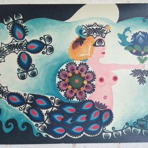 May include: A colorful folk art painting of a mermaid with a floral crown, holding a blue flower. The mermaid has a pink body and a blue and black tail with peacock-like feathers. The background is a dark blue with a turquoise wave.