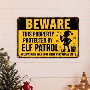 May include: A rectangular metal sign with a yellow background and black text that reads BEWARE THIS PROPERTY PROTECTED BY ELF PATROL and TRESPASSERS WILL LOSE THEIR CHRISTMAS GIFTS, featuring a black silhouette of an elf holding a walkie-talkie.