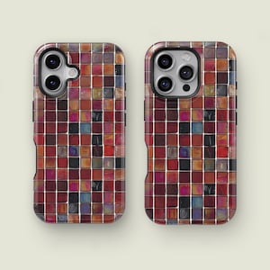 May include: Two phone cases with a mosaic tile design. The cases feature a grid pattern of small, square tiles in shades of red, brown, and hints of blue and black. The cases are designed to fit a smartphone.
