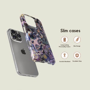 May include: A silver smartphone with a colorful, patterned phone case. The case features a design with purple, blue, and pink hues. The text "Slim cases" is visible, along with icons indicating features like scratch resistance and grip.