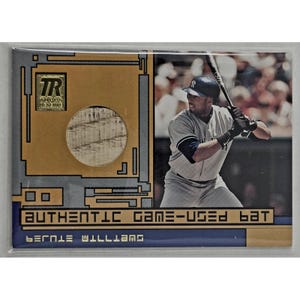 May include: A Topps Reserve trading card featuring a circular piece of wood embedded in a gold and blue frame. The card displays a photograph of a baseball player in a uniform holding a bat, with the text AUTHENTIC GAME-USED BAT and BERNIE WILLIAMS.