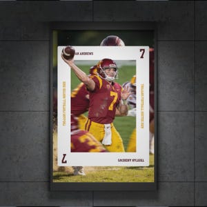 Könnte beinhalten: Ein gerahmtes Poster mit einem Footballspieler in einem weinroten und goldenen Trikot, der einen Football wirft. Das Poster enthält den Text "AN ANDREWS" und "TRISTAN ANDREWS", zusammen mit "TROJANS FOOTBALL ROSTER 2028" und der Zahl "7".