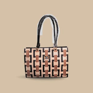 May include: A rectangular handbag with a geometric pattern in black, brown, and beige. The bag has black handles and gold-coloured hardware. The handles are wrapped in clear plastic.
