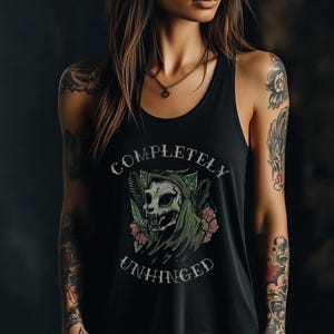 May include: Black tank top with a graphic print of a skull wearing a hood and surrounded by flowers. The text "COMPLETELY UNHINGED" is printed below the skull.
