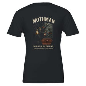 Puede incluir: Camiseta negra con un gráfico de Mothman limpiando una ventana. El diseño incluye el texto "Mothman Window Cleaning" y el lema "Always Watching. Always Wiping."