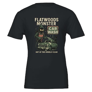 May include: Black t-shirt featuring a graphic of the Flatwoods Monster washing a vintage green car at a car wash. The text reads "Flatwoods Monster Car Wash" and "Out of this World Clean."