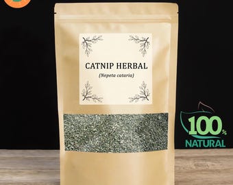 Puede incluir: Una bolsa de papel kraft con una ventana transparente que muestra hierba gatera seca. La bolsa presenta el texto "CATNIP HERBAL (Nepeta cataria)" y una etiqueta "100% NATURAL". La bolsa está sellada.
