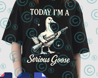 Op de afbeelding: Zwart T-shirt met de tekst "TODAY I'M A Serious Goose". De afbeelding toont een gans met een geweer. Het ontwerp is in wit en lichtblauw. Het shirt heeft korte mouwen.
