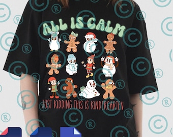 May include: Black t-shirt with the text "ALL IS CALM" in green bubble letters and "JUST KIDDING THIS IS KINDERGARTEN" in a cursive font. The shirt features cartoon gingerbread people, snowmen, and other holiday characters.