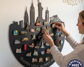 May include: A black, semi-circular wall decor piece with a city skyline silhouette and the words "Wander often, wonder always." It holds numerous colorful travel-themed magnets. The magnets depict landmarks like the Eiffel Tower and the Statue of Liberty.