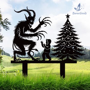 May include: Black metal yard art featuring a Krampus figure with a child and a Christmas tree. The Krampus has horns, claws, and a long tail. The tree has a star on top and decorative cutouts. The art is mounted on a horizontal bar.