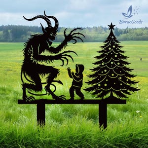 May include: Black metal yard art featuring a Krampus figure with a child and a Christmas tree. The Krampus has horns and long claws, reaching towards the child. The tree is decorated with star and dot ornaments.
