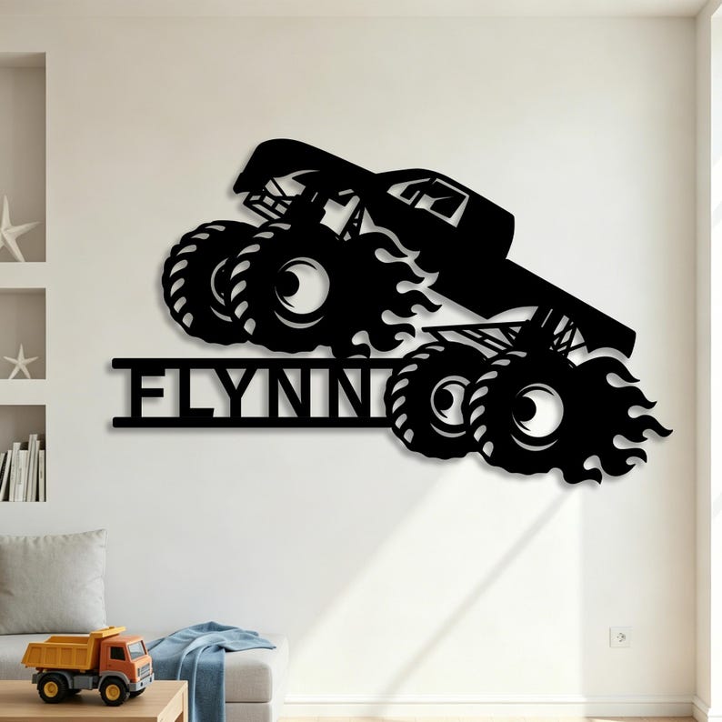 May include: Black metal wall art of a monster truck with flames and the word "FLYNN" in a bold font. The truck has large tires and is angled as if in motion. This decorative piece is suitable for a child's room or a garage.