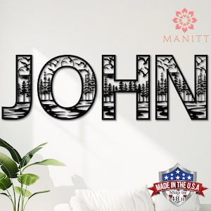 Pode incluir: Arte de parede em metal preto que soletra "JOHN", apresentando uma cena da natureza dentro de cada letra. O design inclui &aacute;rvores, &aacute;gua e p&aacute;ssaros voando. A marca "MANITT" &eacute; vis&iacute;vel, juntamente com um emblema "Made in the U.S.A.".