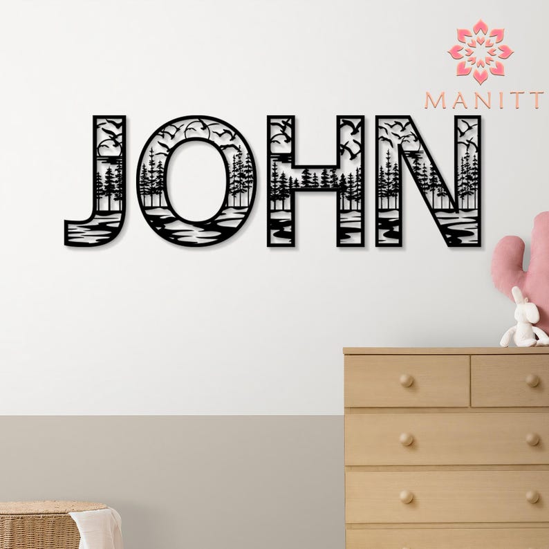 Pode incluir: Arte de parede em metal preto com a palavra "JOHN", com uma cena da natureza dentro de cada letra. O design inclui &aacute;rvores, &aacute;gua e p&aacute;ssaros voando, criando uma pe&ccedil;a decorativa e personalizada.