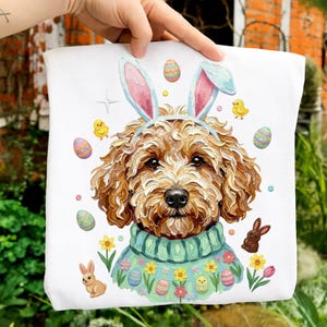 Könnte beinhalten: Weiße Tragetasche mit einem braunen Hund, der Hasenohren und einen türkisfarbenen Pullover trägt. Das Design umfasst Ostereier, Küken, Blumen und einen braunen Hasen. Das Kunstwerk hat einen gemalten Stil.