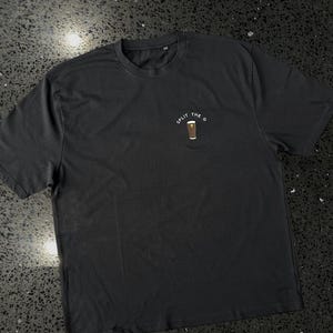 May include: Black t-shirt with a white graphic of a pint of beer and the text "Split the G".