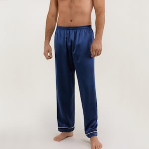May include: Navy blue satin pajama pants with a white trim. The pants have an elastic waistband and a relaxed fit.