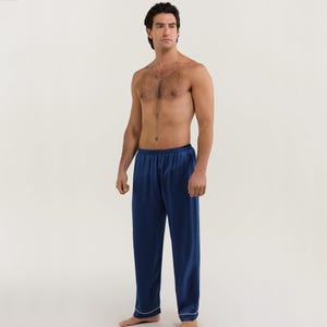 May include: Navy blue satin pajama pants with a white trim. The pants have an elastic waistband and a relaxed fit.