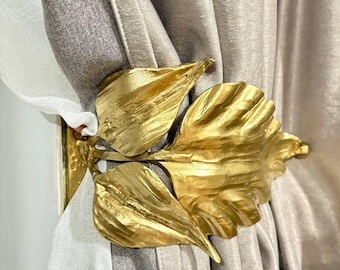Wrought iron curtain tiebacks in leaf design: gold, bronze, or black. Custom curtain rods. Window design.