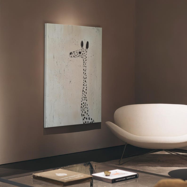 May include: A white chair with a curved back and a white canvas painting of a black and white giraffe on a light brown wall.