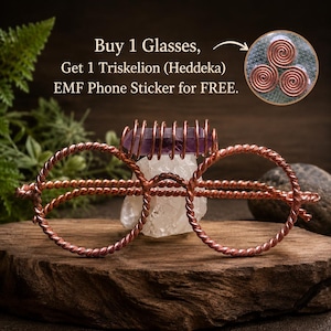 Könnte beinhalten: Dekorative Brille aus gedrehtem Kupferdraht mit einem horizontalen violetten Kristallstab oben. Der Text lautet: Buy 1 Glasses, Get 1 Triskelion (Heddeka) EMF Phone Sticker for FREE, mit einem Inset, das ein Kupferspiraldesign zeigt.