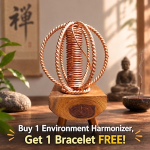 Peut inclure: Une sculpture en fil de cuivre composée d'une bobine verticale centrale entourée de deux anneaux torsadés entrelacés, fixée sur un petit bloc de bois rectangulaire à quatre pieds. Le texte indique : Buy 1 Environment Harmonizer, Get 1 Bracelet FREE!