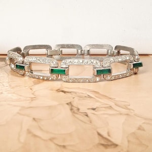 Puede incluir: Una taza de cerámica blanca con un asa negra y el texto "But First, Coffee" en negrita negra. La taza está sobre una superficie blanca. La taza mide aproximadamente 10 cm de alto.