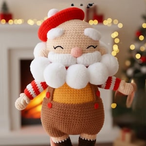 May include: A crocheted Santa Claus doll with a red beret, white beard, and a smiling face. The doll wears a yellow shirt, brown overalls with red buttons, and red and white striped sleeves. A festive Christmas decoration.