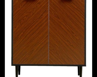 May include: A brown wooden cabinet with two doors and black metal hardware. The cabinet has black legs and a black frame.