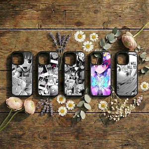 May include: Five black phone cases with manga-style artwork. The cases feature various designs, including black and white comic panels, a collage of faces, and a colorful anime character with a butterfly. The cases are arranged on a wooden surface.