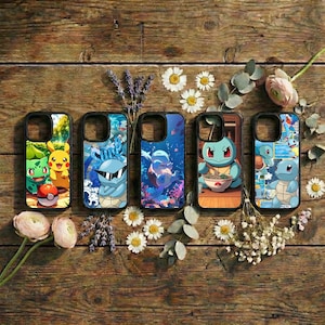 May include: Five phone cases with colorful designs featuring popular cartoon characters. The cases are arranged on a rustic wooden surface, surrounded by flowers and greenery. Each case has a unique design, including a red and white Pokeball.