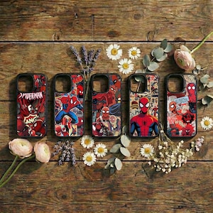 Könnte beinhalten: Fünf Handyhüllen mit Spiderman-Designs. Jede Hülle zeigt eine andere Illustration des Superhelden im Comic-Stil in Rot, Blau und Schwarz. Die Hüllen sind auf einer Holzoberfläche mit Blumen angeordnet.