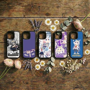 May include: Five phone cases with various anime-style designs. The cases feature a range of colors, including white, purple, and blue, with illustrations of characters and text. The cases are arranged on a wooden surface with flowers and greenery.