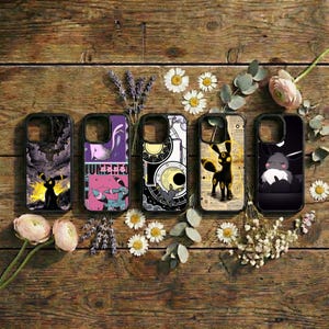 May include: Five phone cases with unique designs featuring a black Umbreon character. The cases are black with colorful graphics, including a night sky, geometric shapes, and text. The cases are arranged on a wooden surface with flowers.