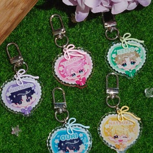 Pode incluir: Cinco porta-chaves de acrílico em forma de coração com personagens de estilo anime chamados Rintaro, Tamon, Keito, Ouri e Natsuki. Cada porta-chaves tem um fecho de mosquetão de metal prateado e um pequeno laço colorido no topo.