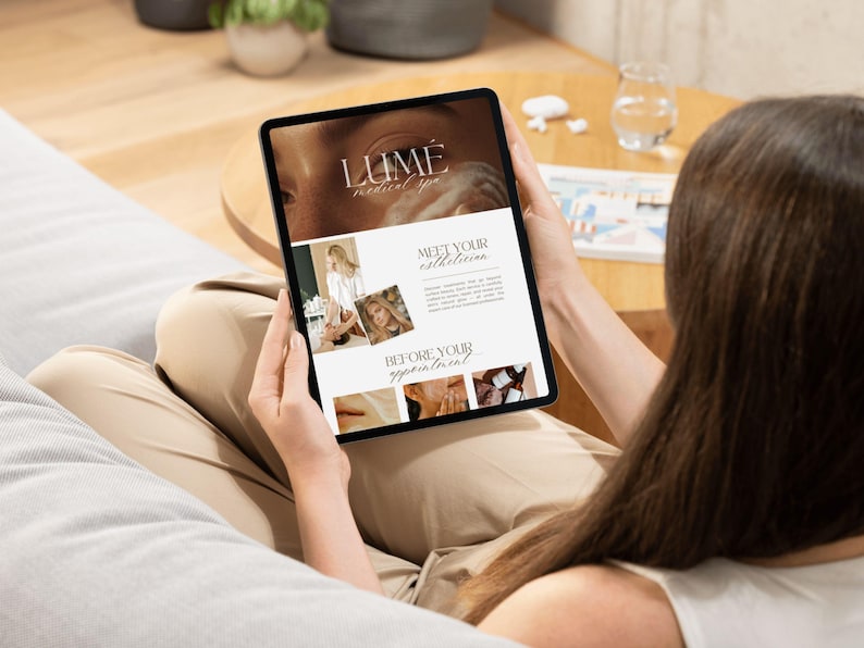 May include: A person holding a tablet displaying a website for Lume Medical Spa. The website features images of estheticians and spa services. The tablet is black and the person is wearing beige pants.