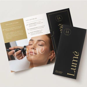 May include: An open brochure and two black pamphlets with gold lettering. The brochure features a woman's face and the word "Lumé" in a large font. The pamphlets also display the word "Lumé" and the phrase "Where Science Meets Beauty".
