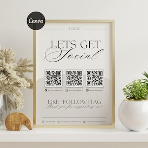 Może przedstawiać: Oprawiony wydruk ze złotą ramką, z napisem "LETS GET Social" w eleganckiej czcionce. Poniżej znajdują się trzy kody QR z nazwami użytkowników mediów społecznościowych. Na dole napis "LIKE | FOLLOW | TAG" i "Thank you for supporting us!"