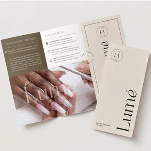 Puede incluir: Un folleto abierto y dos tarjetas de visita para Lume Nails. El folleto presenta texto y una foto de uñas largas y cuidadas. Las tarjetas de visita son de color crema con el logotipo y el texto de Lume.