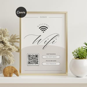 以下が含まれることがあります： 金色の縁取りのある額入りのサインで、WiFiネットワークのサインを表示しています。「Welcome」の文字とWiFiのシンボル、そしてエレガントな筆記体で「Wifi」の文字が特徴です。下にはQRコードとネットワーク名とパスワードのフィールドがあります。