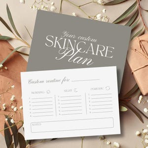 Puede incluir: Tarjeta gris de plan de cuidado de la piel con texto blanco "Your custom SKINCARE Plan". Debajo, una tarjeta blanca ofrece espacio para una rutina personalizada, dividida en secciones de ma&ntilde;ana, noche y peri&oacute;dica.