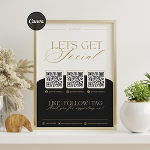 May include: Framed poster with the text "LETS GET Social" in gold script. Below are three QR codes and the words "LIKE | FOLLOW | TAG". The poster includes social media handles and contact information.