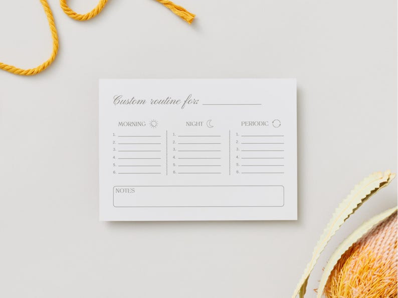 Puede incluir: Un bloc de notas blanco con una plantilla de rutina personalizada. La plantilla incluye secciones para tareas de la ma&ntilde;ana, la noche y peri&oacute;dicas, con l&iacute;neas para enumerar actividades. El bloc de notas tiene el texto "Custom routine for" en la parte superior y "Notes" en la parte inferior. Cuerda amarilla y un objeto decorativo en el fondo.