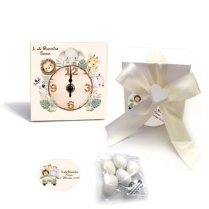 Könnte beinhalten: Eine quadratische Uhr mit Safari-Tieren, darunter ein Löwe, ein Elefant, eine Giraffe, ein Zebra und ein Nilpferd. Das Zifferblatt ist beige mit braunen Zahlen. Eine weiße Geschenkbox mit cremefarbenem Band und herzförmigem Anhänger ist ebenfalls vorhanden.